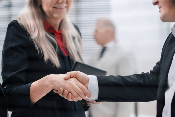 close up. businessman and businesswoman shaking hands with each other. - Photo, Image