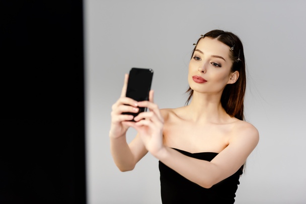 hermosa mujer tomando selfie en gris y negro
 - Foto, Imagen