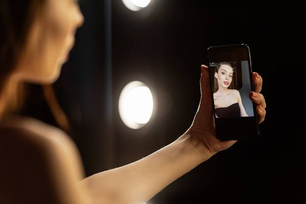 foco seletivo da mulher tomando selfie no estúdio de fotografia
  - Foto, Imagem