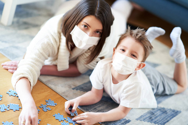 Мать и ребенок играют вместе в домашней изоляции duringcoronavirus пандемии
 - Фото, изображение