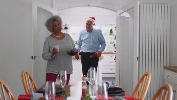 Senior couple at home setting and decorating table for Christmas meal with crackers - shot in slow motion - Filmmaterial, Video