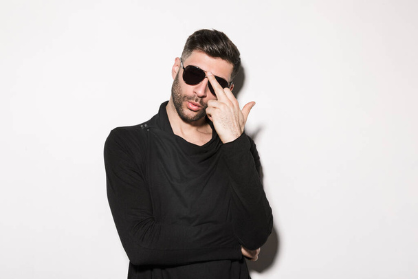 Image of young bearded handsome man wearing sunglasses posing at camera isolated over white background - Φωτογραφία, εικόνα