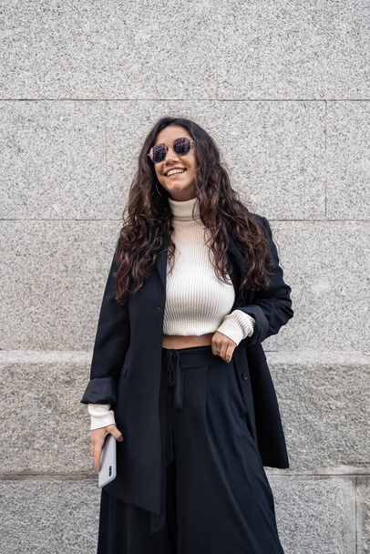 Stock photo of a young caucasian woman smiling. She is wearing smart casual clothes and sunglasses. - Fotó, kép