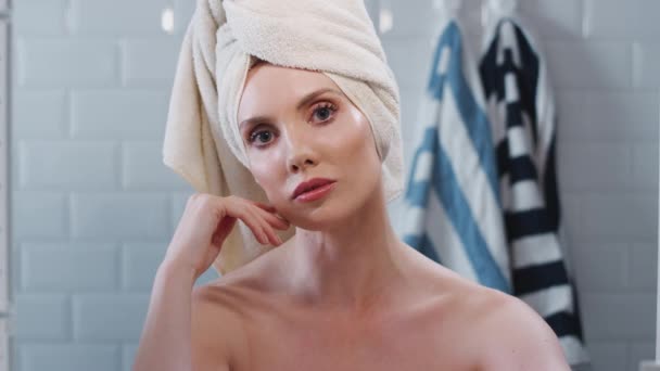 View as though reflected in  bathroom mirror of young woman with towelling turban getting ready in the morning - shot in slow motion - Filmagem, Vídeo