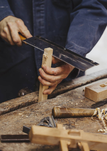 плотник за работой с деревообработкой
 - Фото, изображение