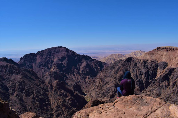 panoramica de una persona sentada viendo el paisaje del parque nacional de petra - Foto, Imagen