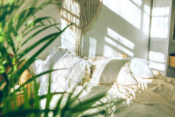Уютная солнечная спальня с крупным планом зеленых свежих листьев домашней пальмы. Интерьер городских джунглей
. - Фото, изображение