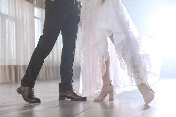 Newlywed couple dancing together in festive hall, closeup of legs - Fotó, kép