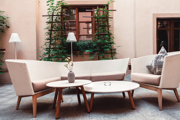Место для отдыха с креслами и диваном из соломы во дворе на фоне дома
 - Фото, изображение