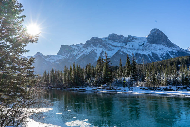 Καναδικό τοπίο. Άποψη του χιονιού καλύπτονται ορεινό τοπίο, Bow River και τρεις αδελφές το χειμώνα. Όμορφη ηλιόλουστη μέρα στα Καναδικά Βραχώδη Όρη. Canmore, Alberta, Καναδάς. - Φωτογραφία, εικόνα