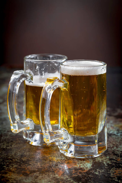 Light beer in a glass, on an old background. - Фото, изображение