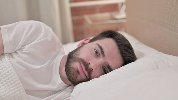 Attractive Young Man Looking at Camera in Bed - Fotografie, Obrázek