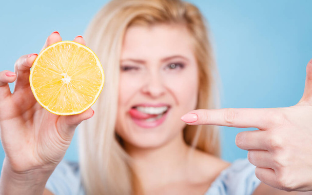 Healthy diet, refreshing food full of vitamins. Woman holding sweet delicious citrus fruit, lemon on orange. - Fotó, kép