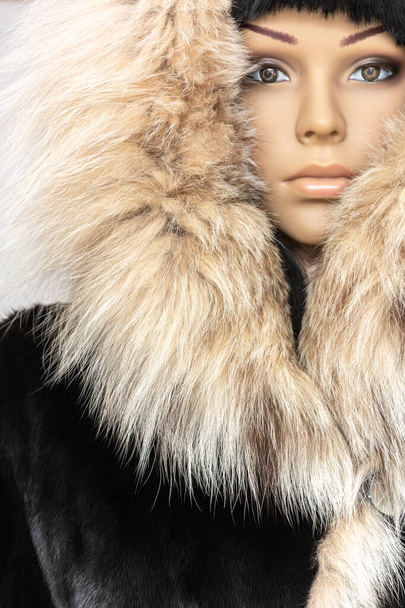 Mode d'hiver vêtements élégants élégants. Manteau de fourrure femme avec capuche sur un mannequin gros plan
 - Photo, image