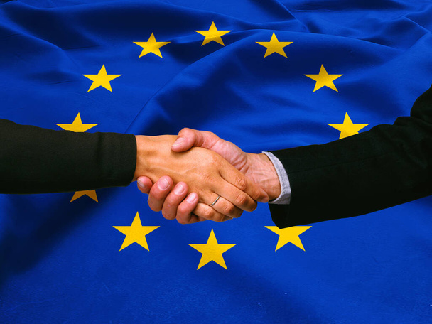 Επιχειρηματική χειραψία στο φόντο της σημαίας της Ευρωπαϊκής Ένωσης  - Φωτογραφία, εικόνα