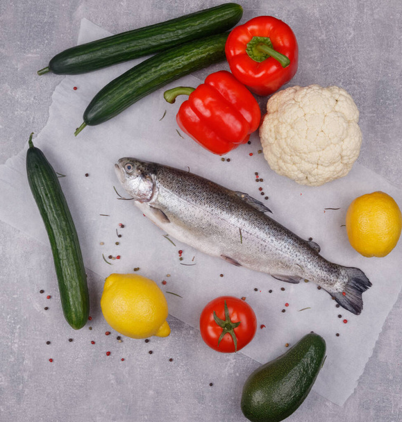 Diet foods: fish, lemon, cucumbers, avocados, peppers, cauliflower and tomato. View from above. Light background. - Valokuva, kuva