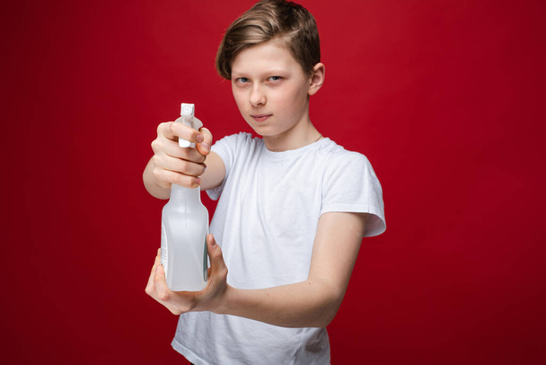 Мальчик с дезинфицирующим распылителем в бутылке
. - Фото, изображение