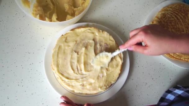 女性の手がクリームケーキをどのように磨くかのトップビュー。女の子スミアケーキとともにクリーム - 映像、動画