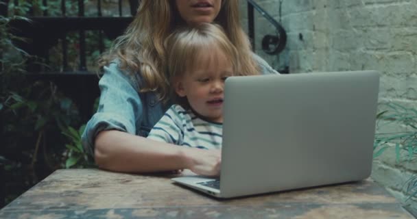 close-up de mãe trabalhando de casa com laptop enquanto criança sentada em suas pernas
 - Filmagem, Vídeo