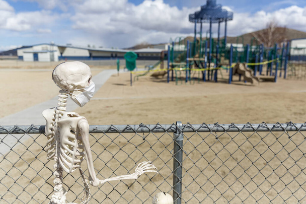 Esqueleto atrás da cerca olhando para um parque fechado vazio em um bom dia
 - Foto, Imagem