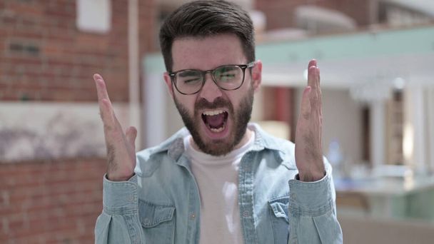 Rozzlobený mladý muž v brýlích křičí - Fotografie, Obrázek
