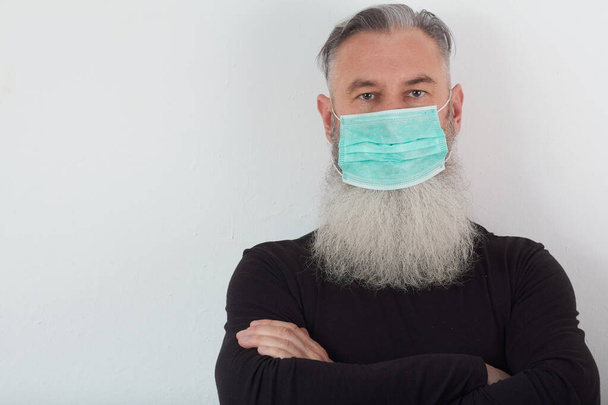 Portrait of middle-aged bearded man in medical mask. A concept of the danger of coronavirus for the elderly. - Photo, Image