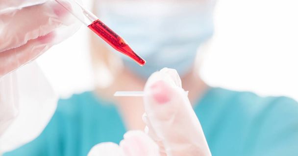 COVID-19 test. Scientist doctor looking at the scientific sample in the laboratory is researching vaccine of Coronavirus. 2019-nCoV Blood Sample. - 写真・画像
