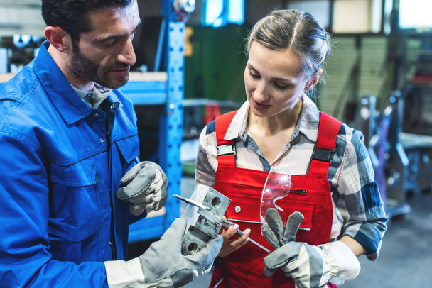 Kadın ve erkek işçi, metal işçiliği ölçümlerini kontrol ediyor. - Fotoğraf, Görsel