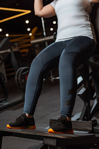 recortado vista de la chica con sobrepeso entrenamiento en la máquina de fitness
 - Foto, Imagen