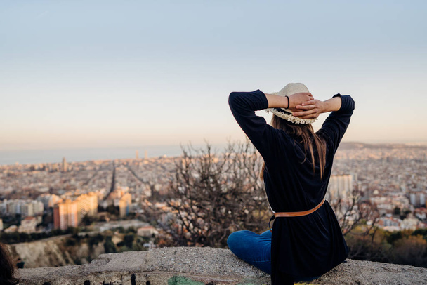 Young woman enjoying the sunset view from Carmen's bunkers in Barcelona,Spain.Best cityscape viewpoint in Barcelona.Tourist attraction and landmark at Bunkers del Carmen, Spain - Foto, afbeelding