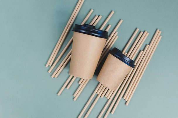 Craft coffee cups with paper straw on gray background. Eco friendly design. Zero waste, plastic free items - Foto, Imagen
