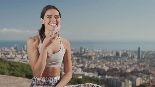 Lächelnd fitte Frau nimmt Sprachnachricht auf Smartphone in der Stadt Barcelona auf - Filmmaterial, Video