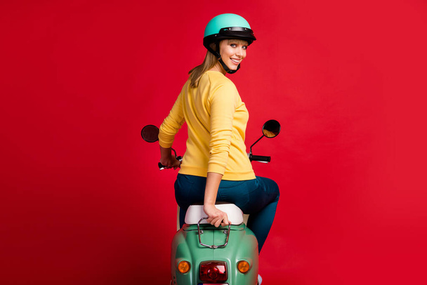 Rear back behind view of her she nice attractive pretty lovely cute cheerful cheery girl driving moped new purchase transport vehicle owner isolated on bright vivid shine vibrant red color background - Photo, Image