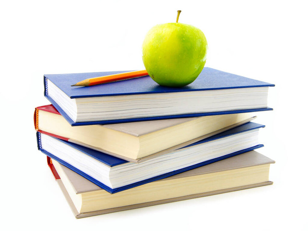 Stapel von Lehrbüchern mit Apfel und Bleistift auf der Oberseite isoliert auf weiß - Foto, Bild
