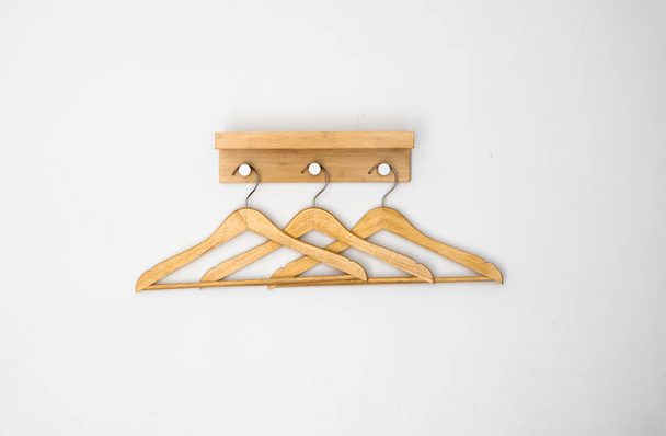 Clothes wooden hangers on a white wall. - Foto, Imagen