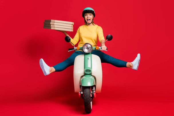 Portrait of her she nice attractive careless girlish cheerful cheery girl riding moped without legs having fun carrying pile stack bakery isolated on bright vivid shine vibrant red color background - Foto, Imagem