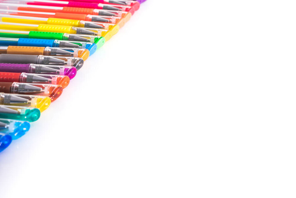 Ensemble de stylos colorés disposés sur une table de studio blanche avec espace de copie isolé. - Photo, image