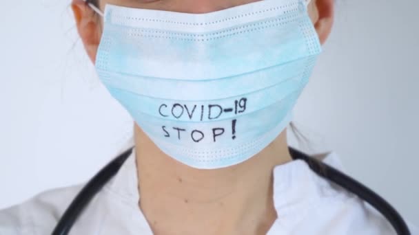 Primo piano del medico caucasico con uno stetoscopio in maschera protettiva. Protezione Covid-19. Interrompi coronavirus - Filmati, video