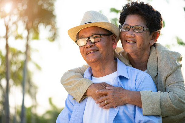 Ein glückliches Seniorenpaar, ein alter Mann und eine Frau, die im Garten lächeln und lachen, eine glückliche Ehe. Seniorengesundheit und Beziehungskonzept. - Foto, Bild