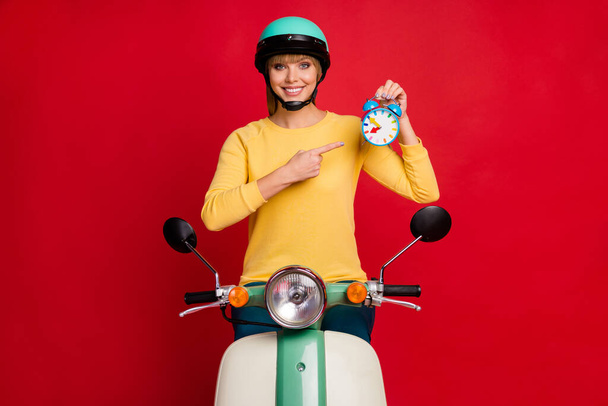 Positive sporty girl biker ride motorbike point index finger clock show her best time sport competition have deadline wear stylish trendy yellow sweater isolated bright shine color background - Foto, Bild