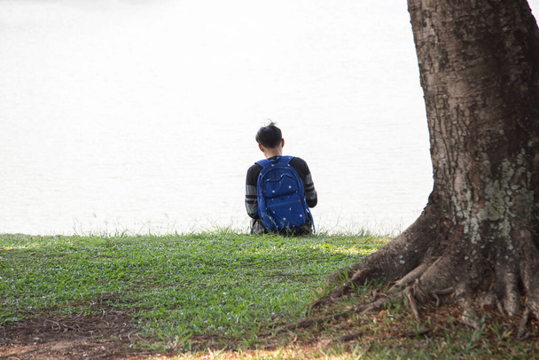 Teenageři sedí na trávníku v parku. deprese, deprese, bolest, utrpení,  - Fotografie, Obrázek