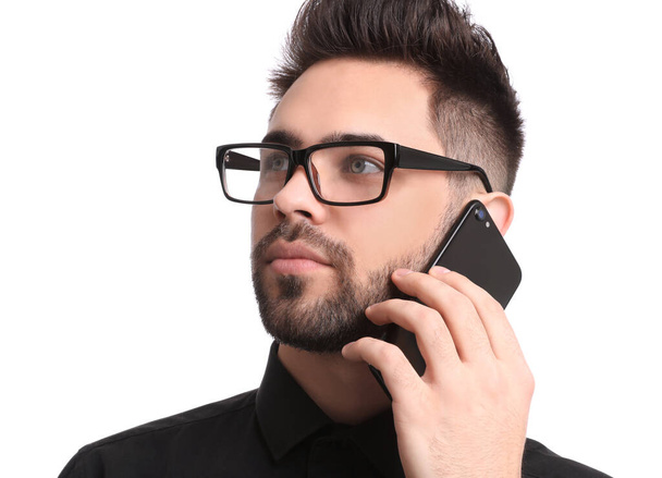 Young businessman talking on smartphone against white background - Fotografie, Obrázek
