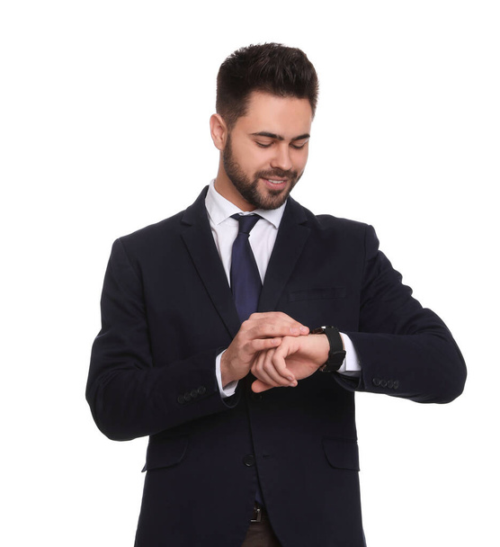 Young businessman checking time on white background - Fotoğraf, Görsel
