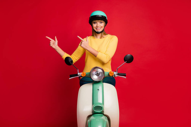 Portrait of her she nice attractive lovely confident cheerful cheery glad girl riding moped showing copy space new novelty isolated on bright vivid shine vibrant red color background - Foto, Bild