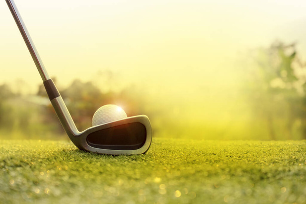 Golf clubs and golf balls on a green lawn in a beautiful golf course with morning sunshine.Ready for golf in the first short.Sports that people around the world play during the holidays for health. - Photo, image