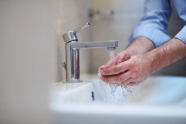 Coronavirus infection and spreading prevention, proper Washing hands with liquid soap. Hygiene male antibacterial hands water wash closeup in bathroom. - Foto, Bild