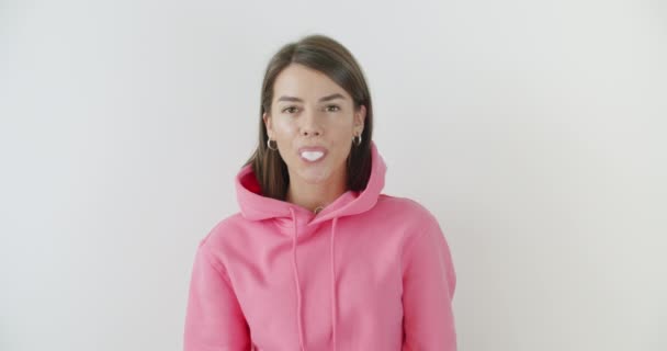 girl dressed in pink hoodie blowing bubblegum - Footage, Video