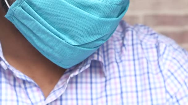 een man met een masker op zijn gezicht voor antivirus bescherming die diep adem haalt  - Video