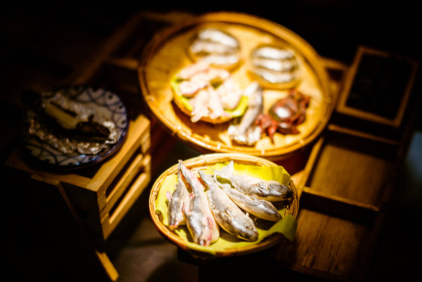 zbliżenie Miniaturowa figurka gliny Tajlandii pływający rynek, Miniaturowa łódź przewożąca owoce tropikalne na tle drewna - Zdjęcie, obraz