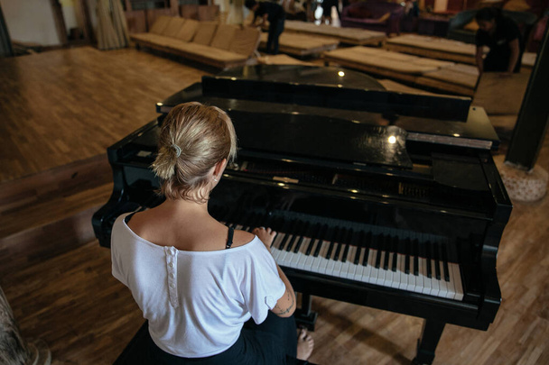 singer plays the black piano - Φωτογραφία, εικόνα